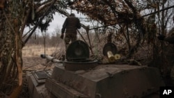 Ukrainian soldiers prepare a self-propelled artillery vehicle to fire at Russian positions on the front line in the Donetsk region, Ukraine, Feb. 16, 2024. 