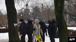 Police officers detain a man as people come to the monument to the victims of political repressions to lay flowers for late Russian opposition leader Alexei Navalny in Saint Petersburg on February 17, 2024, one day after the death of Navalny in an Arctic prison.