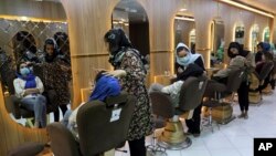FILE- Beauticians put makeup on customers at Ms. Sadat's Beauty Salon in Kabul, Afghanistan, April 25, 2021. A spokesman at Afghanistan's Vice and Virtue Ministry said July 4, 2023, the Taliban are banning women's beauty salons. 