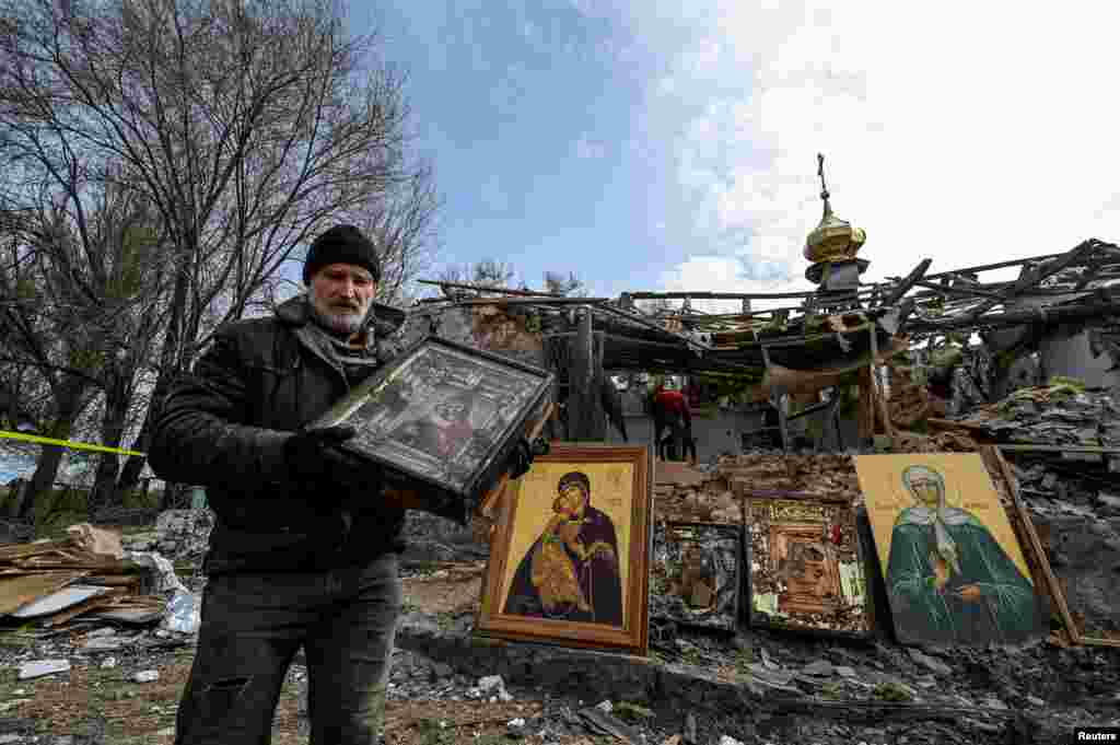 Man carries an Orthodox icon at a site of a church destroyed by a Russian missile strike in the village of Komyshuvakha, Zaporizhzhia region, Ukraine.
