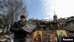 Man carries an Orthodox icon at a site of a church destroyed by a Russian missile strike in the village of Komyshuvakha, Zaporizhzhia region, Ukraine.