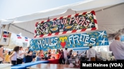 People line up for food between festivities at this year's Fête Française, a New Orleans street festival celebrating French culture on March 25, 2023.