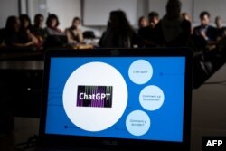 FILE - Participants are seen behind a laptop during a workshop on ChatGPT, in Geneva, Feb. 1, 2023.