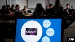 FILE - Participants are seen behind a laptop during a workshop on ChatGPT, in Geneva, Feb. 1, 2023. 