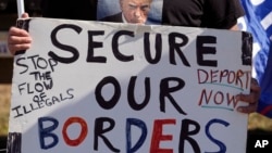 Phill Cady holds a sign during a 'Take Our Border Back' rally, Feb. 3, 2024, in Quemado, Texas.