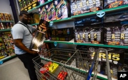 Tishane McFarlane, of Connecticut, puts some firework shells into his cart while shopping at Area 51 Fireworks in Chesterfield, New Hampshire, June 30, 2023.