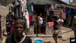 FILE - People displaced by gang violence stand in Jean-Kere Almicar's front yard, where they have sought refuge, in Port-au-Prince, Haiti, June 4, 2023.