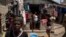 FILE - People displaced by gang violence stand in Jean-Kere Almicar's front yard, where they have sought refuge, in Port-au-Prince, Haiti, June 4, 2023.