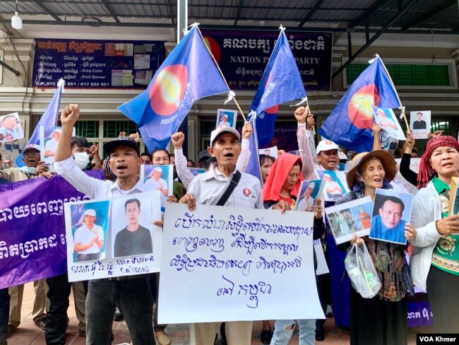 អ្នកគាំទ្រគណបក្សកម្លាំងជាតិ កាន់រូបថត បដា និងស្រែកទាមទារឱ្យដោះលែងសកម្មជននយោបាយ នៅខាងមុខទីស្នាក់ការគណបក្សកម្លាំងជាតិ សង្កាត់ចាក់អង្រែក្រោម ខណ្ឌមានជ័យ នៅថ្ងៃទី២២ ខែមេសា ឆ្នាំ២០២៤។ (លាស់ លីបលីប/វីអូអេ)