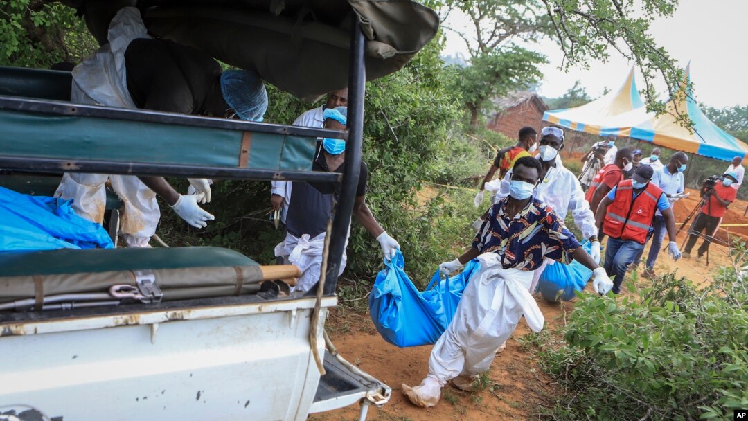 Police and local residents load the exhumed bodies of victims of a religious cult into the back of a truck in the village of Shakahola, near the coastal city of Malindi, in southeastern Kenya, April 23, 2023.
