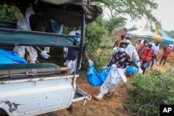 Polisi na wakazi wa eneo wakipakia miili ya watu ambao ni waathirika wa dhehebu linachodaiwa kuwa la udanganyifu. katika kijiji cha Shakahola, karibu na mji wa pwani karibu na Malindi, kusini mashariki ya Kenya, Aprili 23, 2023.