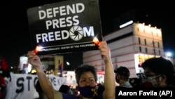 (FILE) Activists hold slogans during a rally in the Philippines.