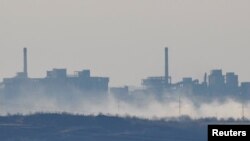 Smoke rises near the Avdiivka Coke and Chemical Plant in the town of Avdiivka during the Russia-Ukraine conflict, as seen from Yasynuvata in the Donetsk region, Russian-controlled Ukraine, Feb.15, 2024. 