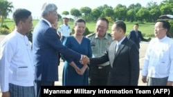 This handout photograph taken on July 6, 2024, and released by the Myanmar Military Information Team shows Myanmar's military Deputy Commander in Chief of Defense Services Soe Win, shaking hands on right, upon his arrival at Qingdao in Shandong province of China.