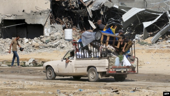 Un hombre palestino conduce una camioneta cargada entre la destrucción causada por un bombardeo israelí anterior en Khan Yunis, en el sur de la Franja de Gaza, el 21 de junio de 2024.