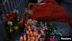 Varios migrantes duermen junto a un altar en el exterior de un centro de detención en Ciudad Juárez, México, donde 40 de ellos murieron en un incendio el 29 de marzo de 2023.