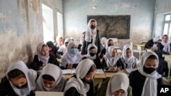 FILE - Afghan schoolgirls in their classroom on the first day of the new school year, in Kabul, March 25, 2023. 