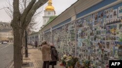 Ljudmila gleda fotografiju svog sina Tymofiija Boyka, ukrajinskog vojnika koji je poginuo u borbi protiv ruskih trupa, na "Zidu sjećanja na poginule za Ukrajinu" u Kijevu, 23. februar 2024.