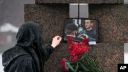 A woman touches a photo of Alexey Navalny after laying flowers at the Memorial to Victims of Political Repression in St. Petersburg, Russia, on Feb. 17, 2024.