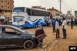 Orang-orang bersiap untuk naik bus yang berangkat dari Khartoum di selatan ibu kota Sudan pada 24 April 2023, di tengah pertempuran antara tentara dan paramiliter. (Foto: AFP)