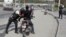 A police officer pats down a motorcyclist at a checkpoint in Port-au-Prince, Haiti, July 1, 2023. 
