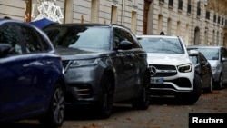 FILE - SUVs are parked on a street in Paris, France, Nov. 20, 2023.