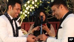 ভারতীয় সমকামী দম্পতি সুপ্রিয় চক্রবর্তী (বামে), এবং অভয় ডাং (ডানে), ভারতের হায়দ্রাবাদের উপকণ্ঠে তাদের এনগেজমেন্ট (বাগদান) অনুষ্ঠানে একে অপরকে রিং পরিয়ে দিচ্ছেন৷ শনিবার, ১৮ ডিসেম্বর, ২০২১। (ফাইল ছবি) 