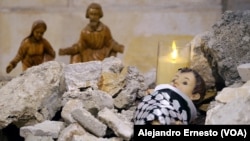 El niño Jesús de la Iglesia Evangélica Luterana de Belén, en Cisjordania, está acostado sobre escombros y arropado con una kufiya o pañuelo tradicional palestino.