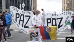 Un colombiano con un traje alusivo a la paz en el que se lee “todos queremos la paz”. [Foto: Federico Vuelvas, VOA]. 