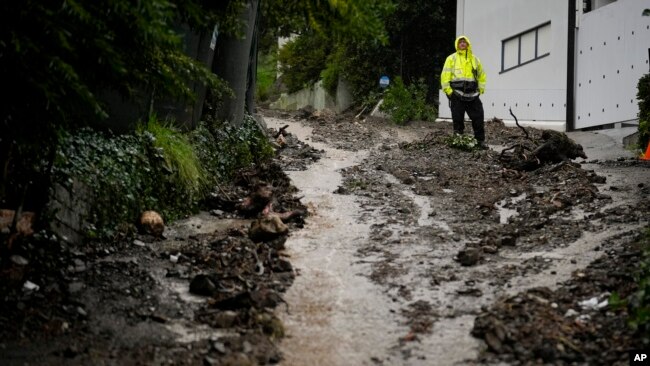 A first responder stands atop a hill in the aftermath of a mudslide in the Beverly Crest area of Los Angeles, California, Feb. 5, 2024.