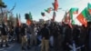 Police personnel stand guard as supporters of Pakistan Tehreek-e-Insaf and other parties protest against alleged rigging of Pakistan's national election results outside the office of a Returning Officer, Feb. 9, 2024, in Quetta, Pakistan.