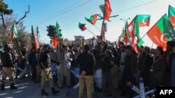 Police personnel stand guard as supporters of Pakistan Tehreek-e-Insaf and other parties protest against alleged rigging of Pakistan's national election results outside the office of a Returning Officer, Feb. 9, 2024, in Quetta, Pakistan.