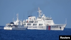 FILE - A Chinese Coast Guard ship allegedly obstructs a Philippine Coast Guard vessel as it provided support during a Philippine Navy operation in the disputed South China Sea, June 30, 2023 in this handout image released July 5, 2023.