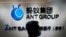 FILE - In this Oct. 23, 2020, photo, an employee walks past a logo of the Ant Group at their office in Hong Kong. 