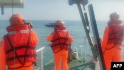 Foto selebaran yang diambil pada 14 Februari 2024 oleh Penjaga Pantai Taiwan dan dirilis pada 15 Februari ini menunjukkan staf Penjaga Pantai Taiwan mengelilingi speed boat China yang terbalik di dekat Kepulauan Kinmen. (Handout / TAIWAN COAST GUARD / AFP)