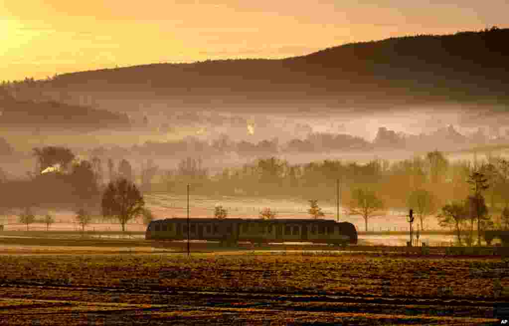 A regional train approaches the station of Wehrheim near Frankfurt, Germany, on a misty morning