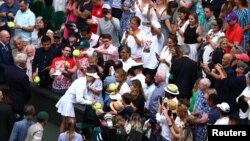 Ukraine's Elina Svitolina signs autographs after winning her quarterfinal match against Poland's Iga Swiatek at the All England Lawn Tennis and Croquet Club in Wimbledon, England, July 11, 2023.