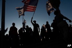 Demonstrators wave flags during a protest against plans to overhaul the judicial system in Tel Aviv, Israel, July 18, 2023.