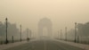 Pedestrians walk along the Kartavya Path in front of the India Gate amid heavy smoggy conditions in New Delhi on November 13, 2023.