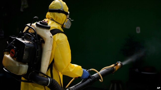 A public health worker sprays insecticide during a fumigation campaign against dengue-promoting mosquitoes, in the Ceilandia neighborhood of Brasilia, Brazil, Feb. 16, 2024.