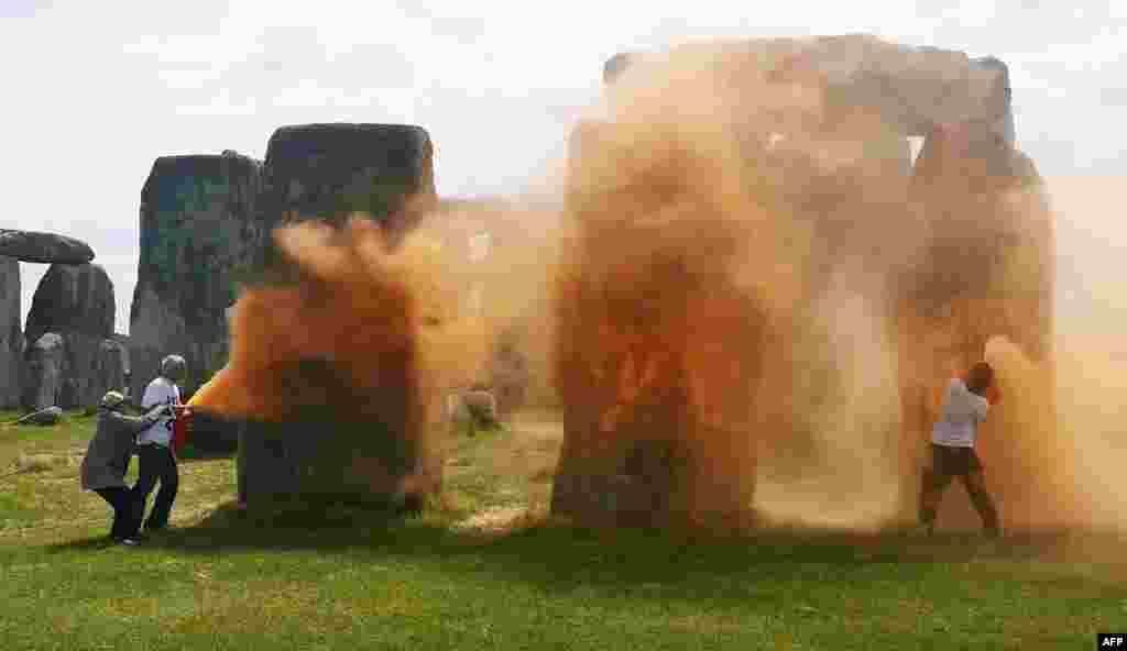 An image grab from a video released by the Just Stop Oil climate campaign group shows activists spraying an orange substance at Stonehenge in Wiltshire, southwest England.