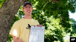 Nate Golden, president of the Maryland Child Alliance, poses for a portrait with a petition form for the Baltimore Baby Fund, in Baltimore, July 3, 2024.