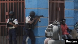 FILE: Police officers take position as they take part in an anti-gang operation in Port-au-Prince, Haiti. Taken March 3, 2023.