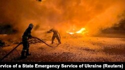 Petugas memadamkan truk yang terbakar yang rusak akibat serangan drone Rusia di kompleks pelabuhan di Sungai Danube di wilayah Odesa, Ukraina, 26 September 2023. (Foto: via Reuters)