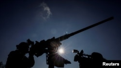 资料照片：一名摄影师在俄罗斯袭击乌克兰期间对着防空部队拍摄。(2024年1月29日)