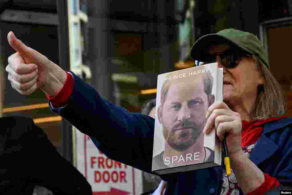 A supporter of Britain&#39;s Prince Harry gives a thumbs up outside the Rolls Building of the High Court in London.