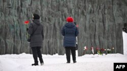 Women with red carnations arrive to lay flowers for late Russian opposition leader Alexei Navalny at the "Wall of Grief" monument to the victims of political repressions in Moscow, Feb. 19, 2024.