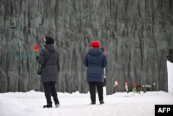 Žene sa crvenim karanfilima stižu da odaju počast ruskom opozicionom lideru Alekseju Navalnom na "Zidu tuge", spomeniku žrtvama političke represije u Moskvi, 19. februara 2024.