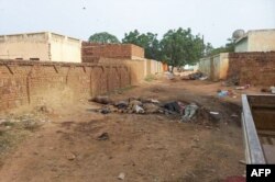 A picture taken on June 16, 2023, shows bodies strewn near houses in the West Darfur state capital amid ongoing fighting in war-torn Sudan.
