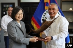 FILE - Taiwan's President Tsai Ing-wen, left, receives a gift from Belize's Prime Minister John Briceño at the Foreign Ministry in Belmopan on April 3, 2023. (Photo by Government of Belize Press Office/AFP)